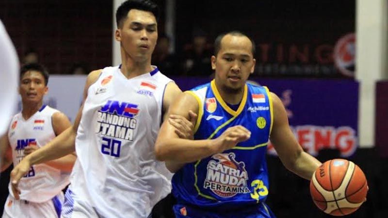 Arki Dikania Wisnu, kapten Satria Muda sedang bidayang-bayangi pemain JNE Bandung Utama. Copyright: © ibl